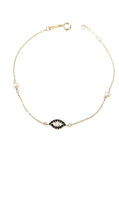 Gold necklace with a black and white gemstone on a white background